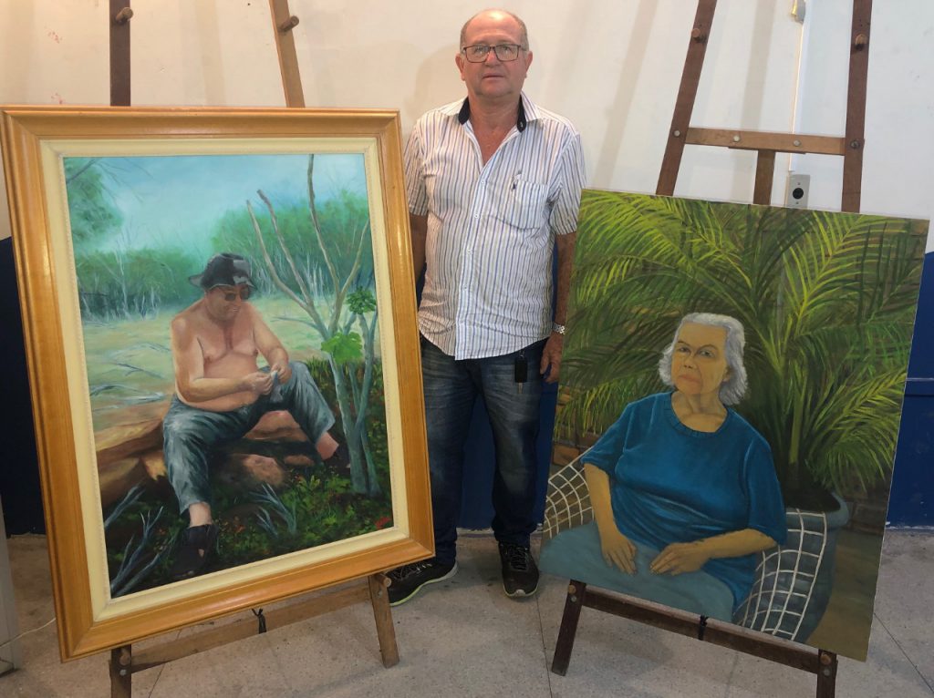 Legenda: O artista Joelson Marinho Lins e as suas duas obras em homenagem aos seus pais. Foto: Nielson Santos